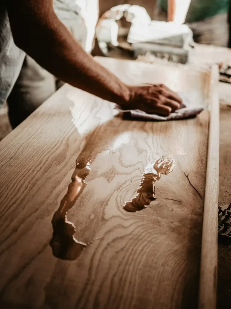 Iemand neemt een houten blad af met een doek